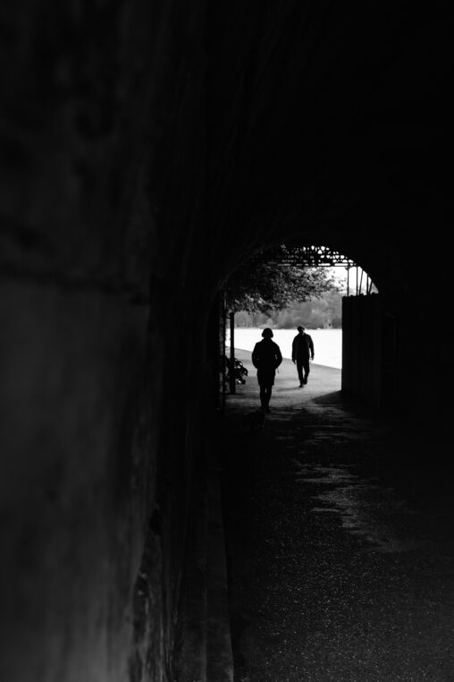 トンネル風の建物の奥で出会う二人の人物